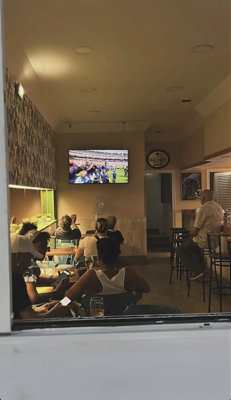Clientes viendo un partido en la pantalla del local