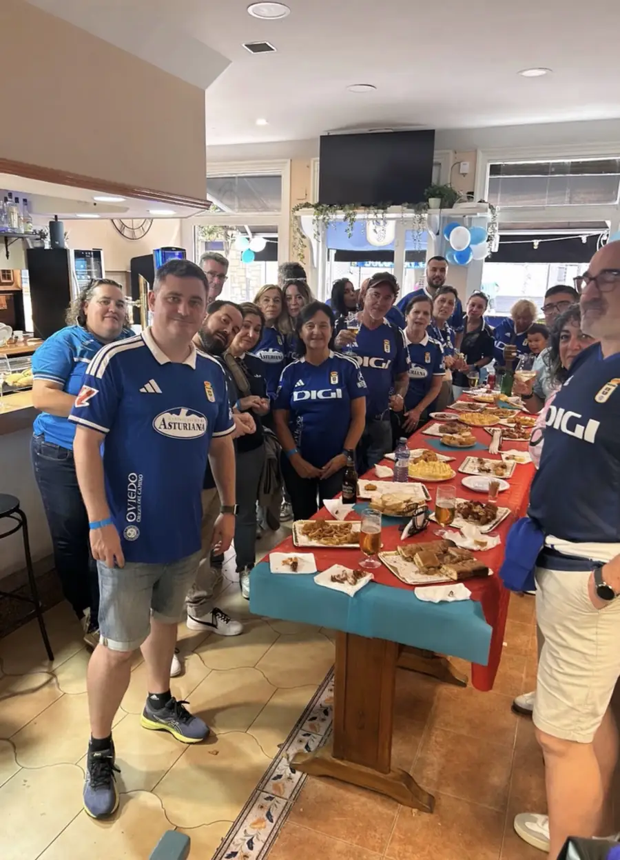 Grupo de aficionados con la camiseta azul del Real Oviedo en el local